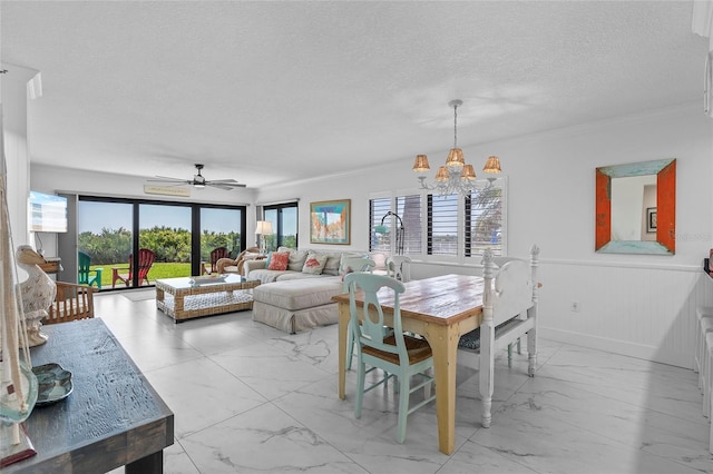 5301 S Atlantic Ave Unit 140, New Smyrna Beach, FL 32169 - dining room featuring light marble finish flooring, a chandelier, ceiling fan, wainscoting, and a textured ceiling