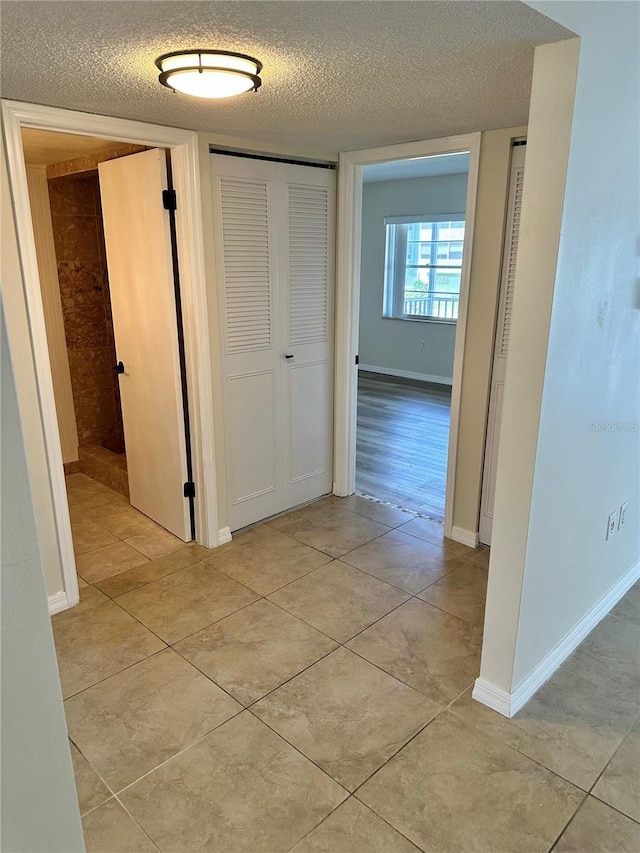 315 N Causeway Unit 2060, New Smyrna Beach, FL 32169 - hall with a textured ceiling, light tile patterned flooring, and baseboards