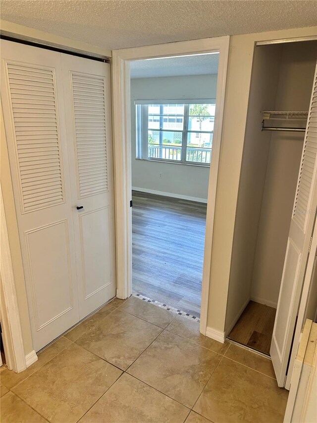 315 N Causeway Unit 2060, New Smyrna Beach, FL 32169 - corridor featuring light tile patterned floors, a textured ceiling, and baseboards