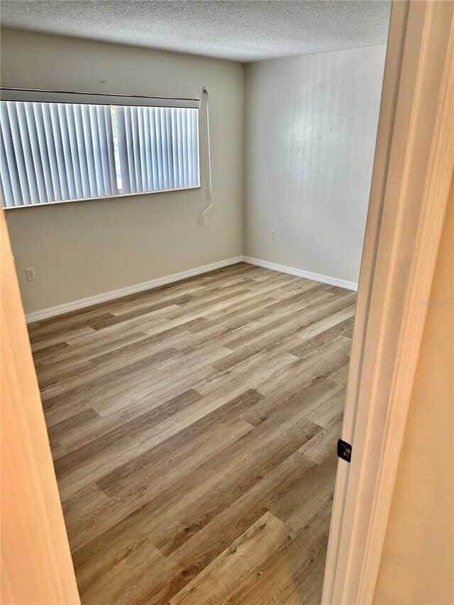 315 N Causeway Unit 2060, New Smyrna Beach, FL 32169 - unfurnished room featuring a textured ceiling and wood finished floors