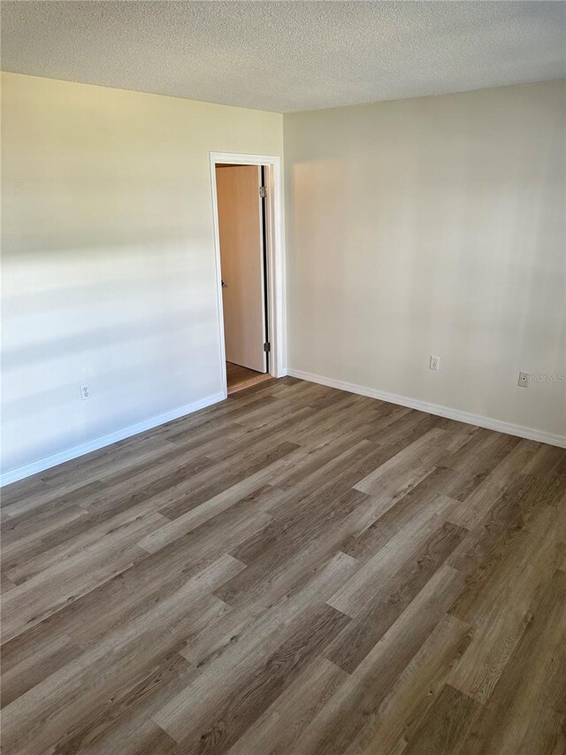 315 N Causeway Unit 2060, New Smyrna Beach, FL 32169 - empty room featuring wood finished floors, baseboards, and a textured ceiling