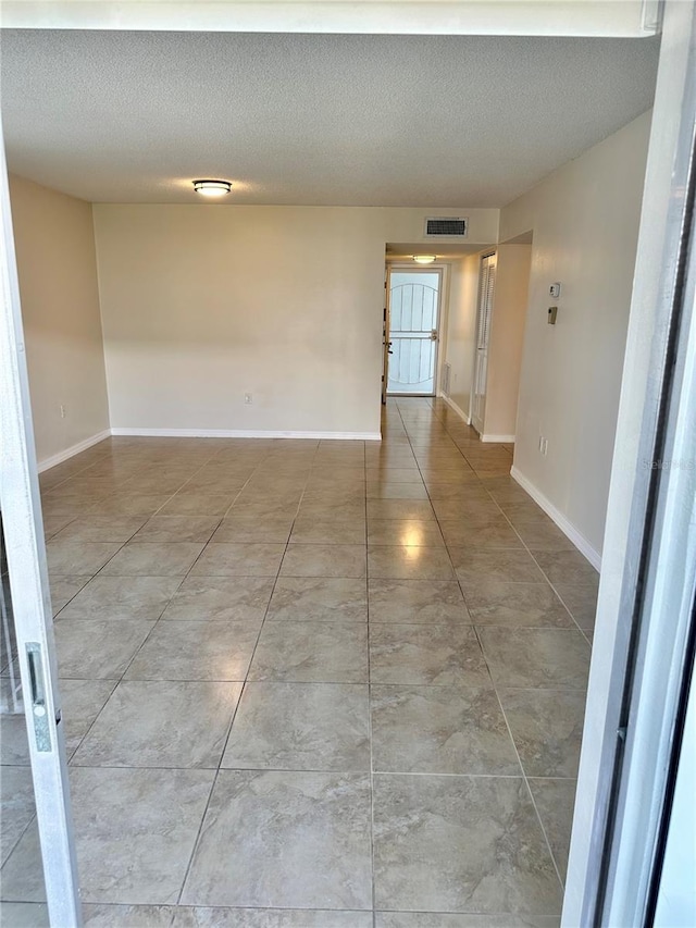 315 N Causeway Unit 2060, New Smyrna Beach, FL 32169 - tiled empty room featuring a textured ceiling and baseboards