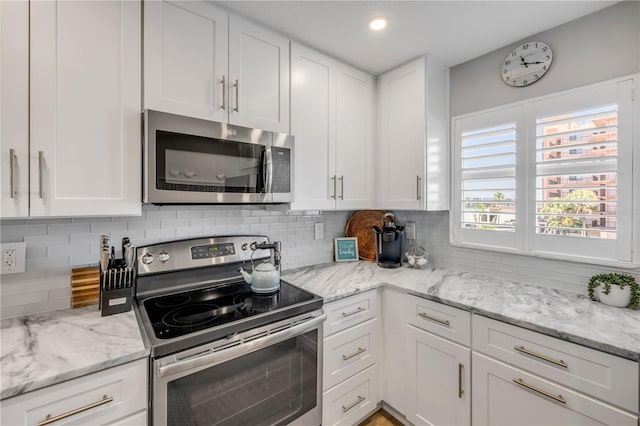 4151 S Atlantic Ave Unit 3090, New Smyrna Beach, FL 32169 - kitchen featuring appliances with stainless steel finishes, white cabinetry, backsplash, light stone counters, and recessed lighting