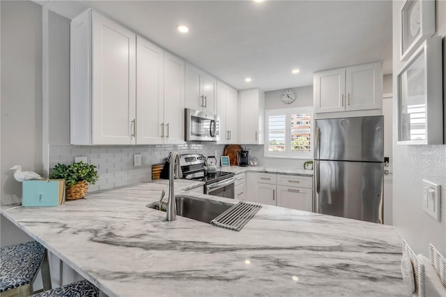 4151 S Atlantic Ave Unit 3090, New Smyrna Beach, FL 32169 - kitchen featuring appliances with stainless steel finishes, light stone counters, tasteful backsplash, white cabinets, and recessed lighting