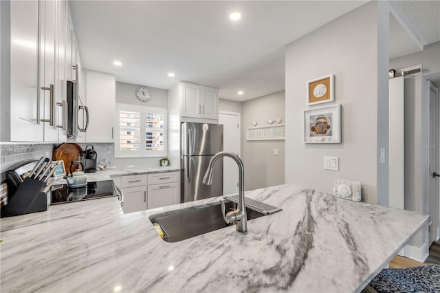 4151 S Atlantic Ave Unit 3090, New Smyrna Beach, FL 32169 - kitchen featuring appliances with stainless steel finishes, a sink, light stone countertops, white cabinetry, and recessed lighting