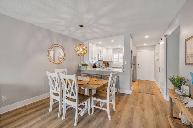 4151 S Atlantic Ave Unit 3090, New Smyrna Beach, FL 32169 - dining space with light wood-type flooring, recessed lighting, baseboards, and a textured ceiling