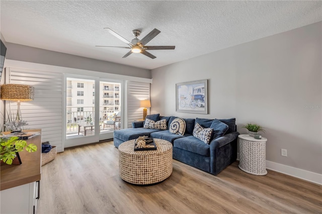 4151 S Atlantic Ave Unit 3090, New Smyrna Beach, FL 32169 - living area featuring ceiling fan, light wood-style floors, a textured ceiling, and baseboards