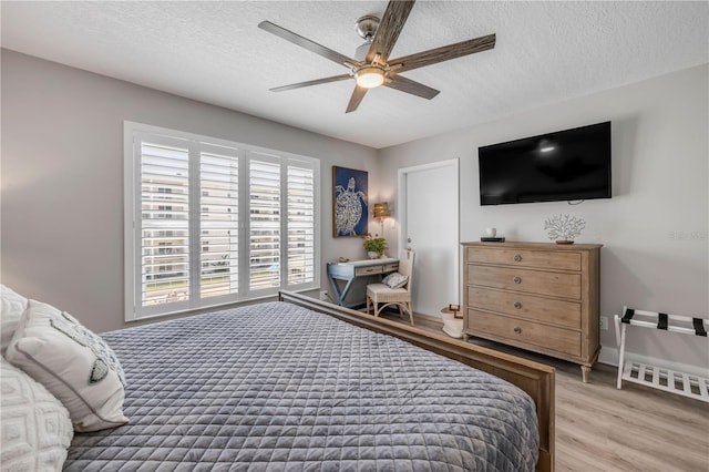4151 S Atlantic Ave Unit 3090, New Smyrna Beach, FL 32169 - bedroom with light wood-style flooring, a textured ceiling, a ceiling fan, and baseboards