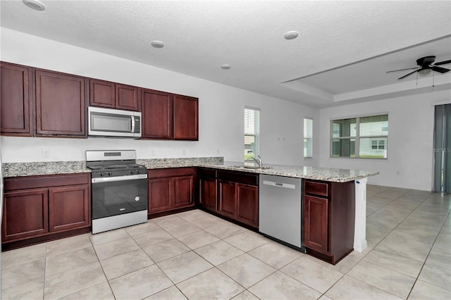 7223 SW 61st Pl, Ocala, FL 34474 - kitchen with stainless steel appliances, healthy amount of natural light, a peninsula, a ceiling fan, and a textured ceiling