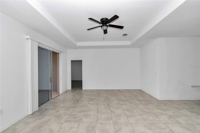7223 SW 61st Pl, Ocala, FL 34474 - empty room with a raised ceiling, ceiling fan, a textured ceiling, and light tile patterned floors
