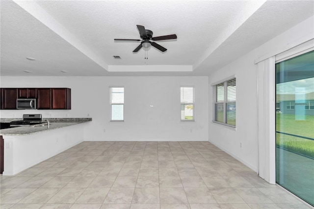 7223 SW 61st Pl, Ocala, FL 34474 - kitchen with appliances with stainless steel finishes, a raised ceiling, a ceiling fan, a textured ceiling, and a peninsula