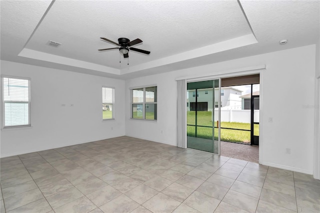 7223 SW 61st Pl, Ocala, FL 34474 - unfurnished room with a tray ceiling, healthy amount of natural light, a ceiling fan, and a textured ceiling