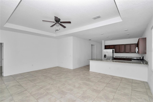 7223 SW 61st Pl, Ocala, FL 34474 - unfurnished living room featuring a raised ceiling, a textured ceiling, and ceiling fan