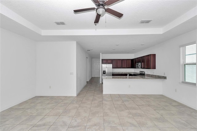7223 SW 61st Pl, Ocala, FL 34474 - kitchen with stainless steel appliances, a textured ceiling, a peninsula, ceiling fan, and light stone countertops