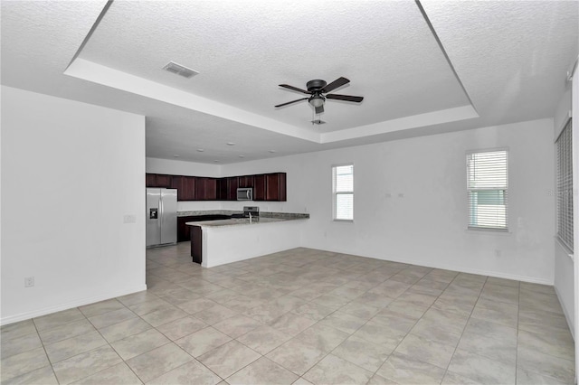 7223 SW 61st Pl, Ocala, FL 34474 - kitchen featuring appliances with stainless steel finishes, a raised ceiling, a peninsula, a textured ceiling, and open floor plan