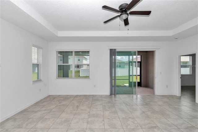 7223 SW 61st Pl, Ocala, FL 34474 - empty room featuring a raised ceiling, a ceiling fan, a textured ceiling, and light tile patterned floors