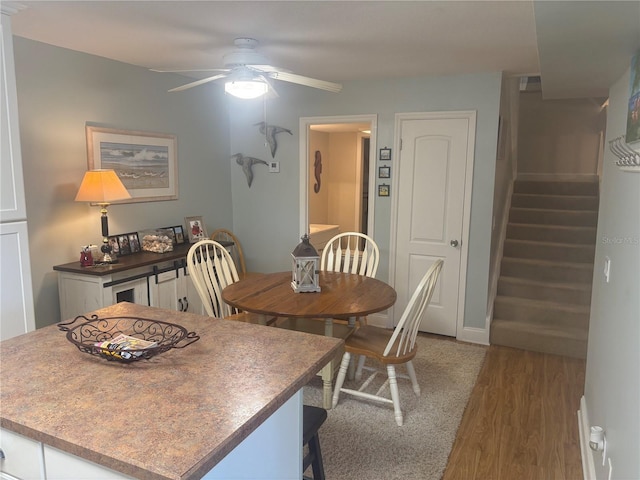 38 Cedar Dunes Dr, New Smyrna Beach, FL 32169 - dining area featuring a ceiling fan, wood finished floors, and stairway