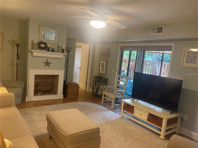 38 Cedar Dunes Dr, New Smyrna Beach, FL 32169 - living room featuring a ceiling fan, wood finished floors, and a fireplace