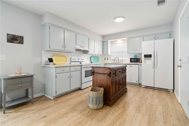 1920 Travelers Palm Dr, Edgewater, FL 32141 - kitchen featuring white appliances, under cabinet range hood, light wood-style floors, light countertops, and a center island