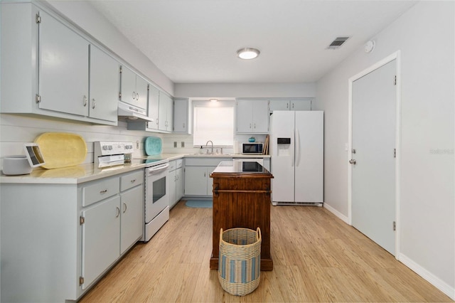 1920 Travelers Palm Dr, Edgewater, FL 32141 - kitchen featuring white appliances, under cabinet range hood, light wood-type flooring, and a center island