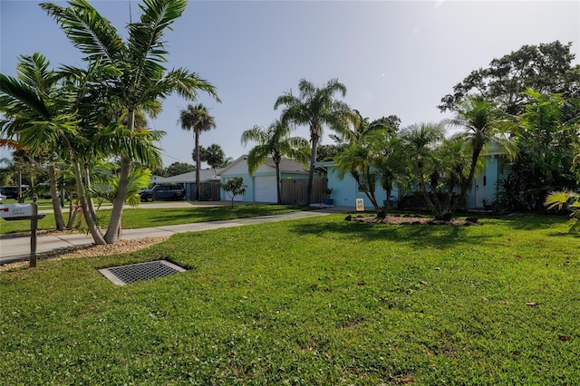 653 Goodwin Ave, New Smyrna Beach, FL 32169 - view of grassy yard featuring driveway and a garage