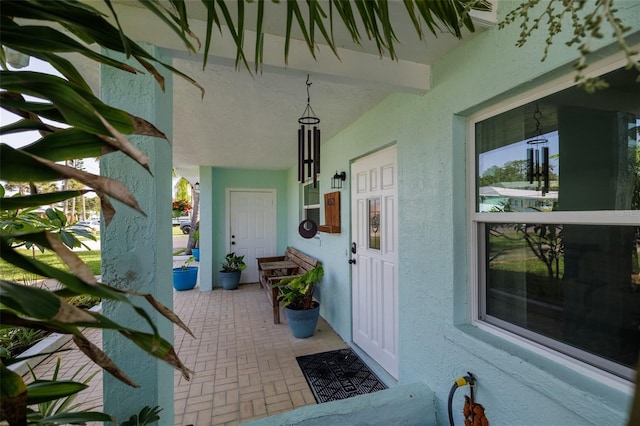 653 Goodwin Ave, New Smyrna Beach, FL 32169 - view of exterior entry with stucco siding and covered porch