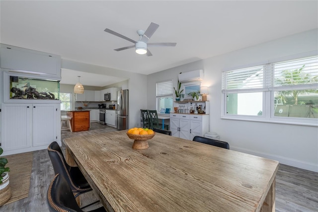 653 Goodwin Ave, New Smyrna Beach, FL 32169 - dining space with wood finished floors, ceiling fan, and a wall unit AC