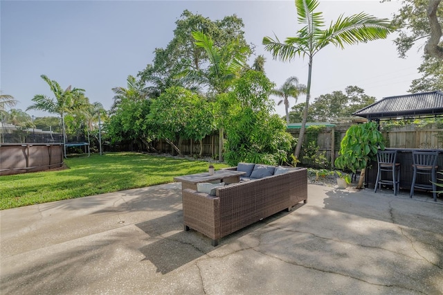 653 Goodwin Ave, New Smyrna Beach, FL 32169 - fenced backyard with an outdoor living space, a patio, and a trampoline