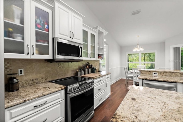 5935 Shady Creek Ln, Port Orange, FL 32128 - kitchen with appliances with stainless steel finishes, a chandelier, white cabinets, dark wood finished floors, and backsplash