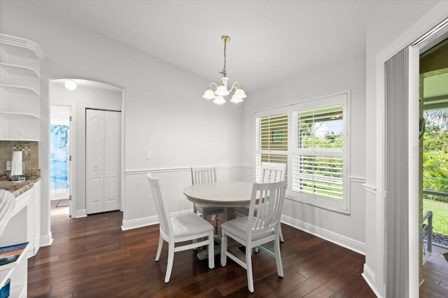5935 Shady Creek Ln, Port Orange, FL 32128 - dining space featuring dark wood-style flooring, a chandelier, arched walkways, and vaulted ceiling