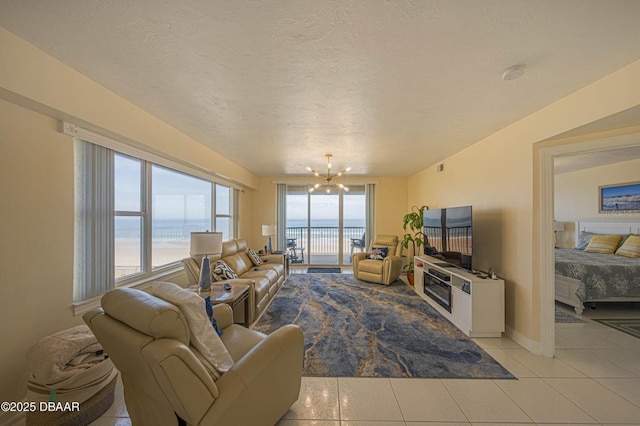 4575 S Atlantic Ave Unit 6203, Ponce Inlet, FL 32127 - living area featuring a chandelier, light tile patterned flooring, baseboards, and a textured ceiling