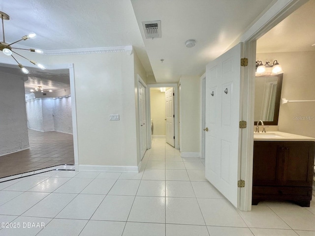 4575 S Atlantic Ave Unit 6203, Ponce Inlet, FL 32127 - hall featuring light tile patterned floors, a chandelier, a sink, and baseboards