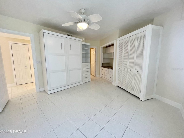 4575 S Atlantic Ave Unit 6203, Ponce Inlet, FL 32127 - unfurnished bedroom featuring light tile patterned floors, baseboards, two closets, and ceiling fan