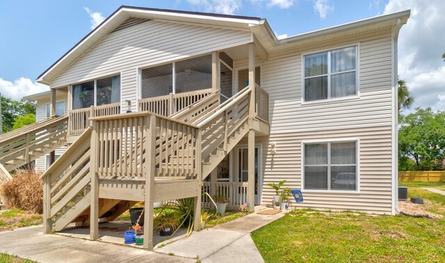 1600 Big Tree Rd Unit R4, South Daytona, FL 32119 - rear view of house featuring stairs, a sunroom, a wooden deck, and a yard