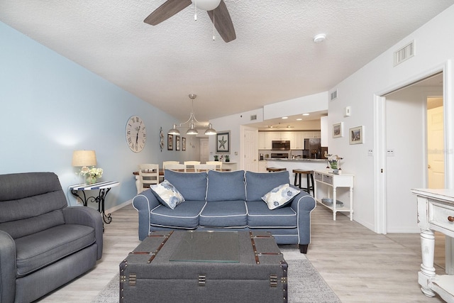 5300 S Atlantic Ave Unit 11302, New Smyrna Beach, FL 32169 - living area with a ceiling fan, light wood-style flooring, baseboards, and a textured ceiling
