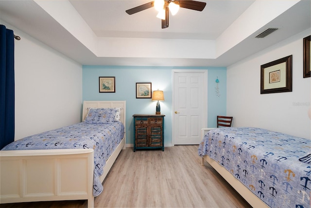 5300 S Atlantic Ave Unit 11302, New Smyrna Beach, FL 32169 - bedroom with light wood-style flooring, a tray ceiling, and ceiling fan