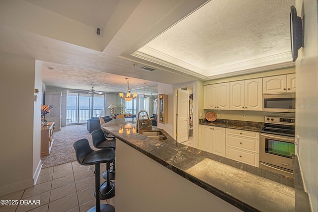 4555 S Atlantic Ave Unit 4405, Ponce Inlet, FL 32127 - kitchen featuring stainless steel appliances, a chandelier, a sink, a textured ceiling, and open floor plan