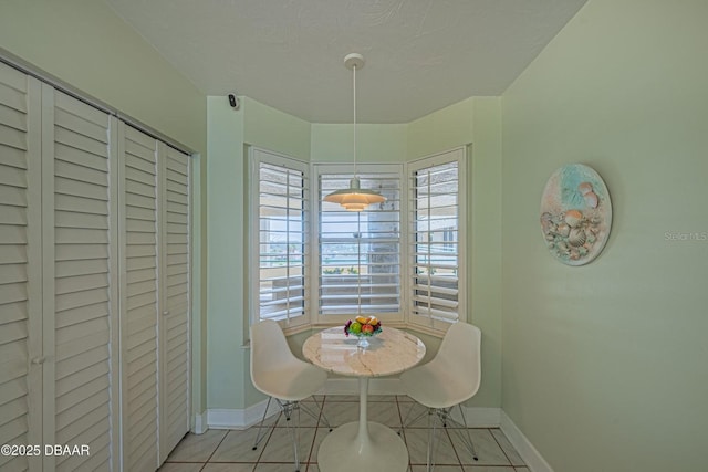 4555 S Atlantic Ave Unit 4405, Ponce Inlet, FL 32127 - dining space featuring light tile patterned floors, baseboards, and a textured ceiling
