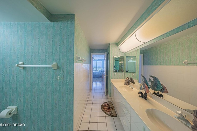 4555 S Atlantic Ave Unit 4405, Ponce Inlet, FL 32127 - full bathroom featuring tile patterned floors, double vanity, wallpapered walls, and tile walls