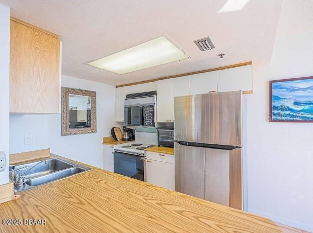 3023 S Atlantic Ave Unit 8010, Daytona Beach, FL 32118 - kitchen with appliances with stainless steel finishes, white cabinetry, and light countertops