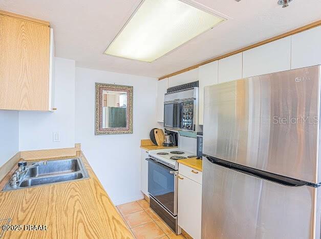 3023 S Atlantic Ave Unit 8010, Daytona Beach, FL 32118 - kitchen with freestanding refrigerator, black microwave, range with electric cooktop, a sink, and light countertops