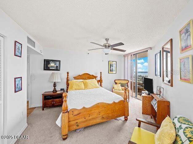 3023 S Atlantic Ave Unit 8010, Daytona Beach, FL 32118 - carpeted bedroom with access to outside, a textured ceiling, ceiling fan, and baseboards