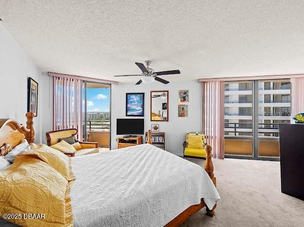 3023 S Atlantic Ave Unit 8010, Daytona Beach, FL 32118 - bedroom featuring carpet, a textured ceiling, access to outside, and a ceiling fan