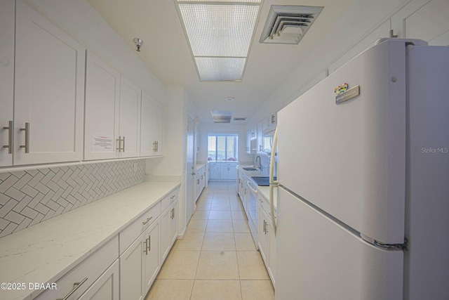 3023 S Atlantic Ave Unit 8010, Daytona Beach, FL 32118 - kitchen with freestanding refrigerator, a sink, white cabinets, and decorative backsplash