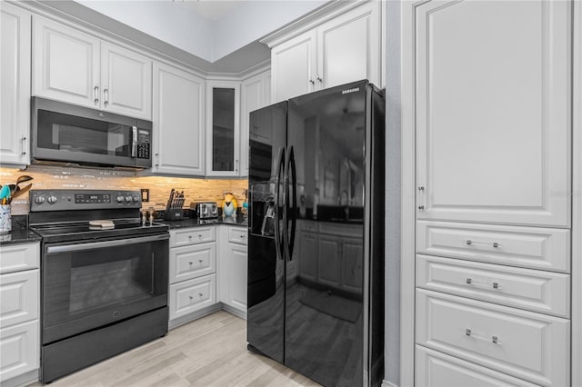 2 Oceans W Blvd Unit 608, Daytona Beach Shores, FL 32118 - kitchen featuring black appliances, white cabinets, light wood-type flooring, glass insert cabinets, and backsplash