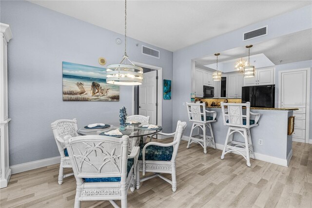 2 Oceans W Blvd Unit 608, Daytona Beach Shores, FL 32118 - dining space featuring a chandelier, light wood-style flooring, and baseboards