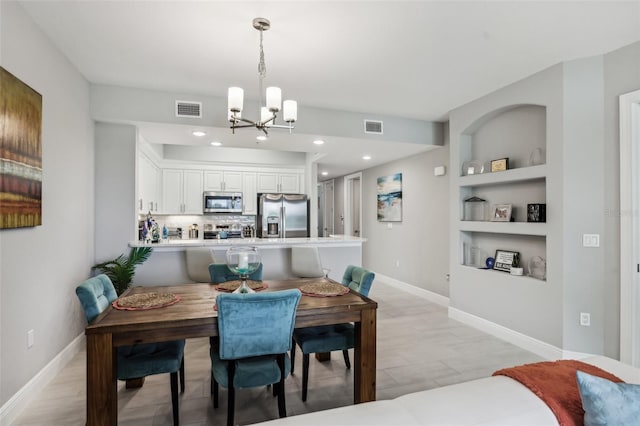 7 Riverwalk Dr Unit 305, New Smyrna Beach, FL 32169 - dining room with a chandelier, baseboards, built in shelves, and recessed lighting