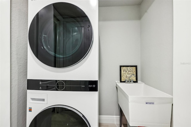 7 Riverwalk Dr Unit 305, New Smyrna Beach, FL 32169 - laundry area featuring stacked washer and clothes dryer and baseboards
