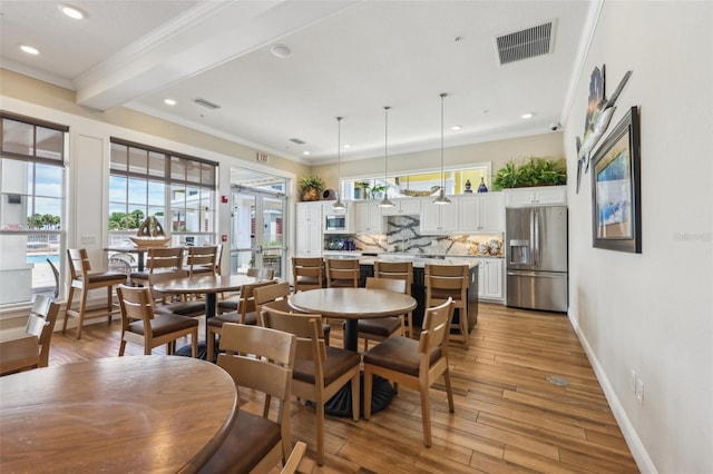 7 Riverwalk Dr Unit 305, New Smyrna Beach, FL 32169 - dining space with crown molding, plenty of natural light, baseboards, light wood-style flooring, and recessed lighting