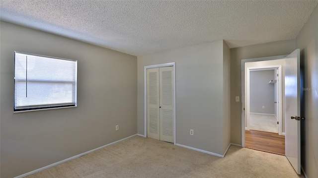 1802 N Fern Palm Dr, Edgewater, FL 32132 - unfurnished bedroom with a closet, light colored carpet, a textured ceiling, and baseboards